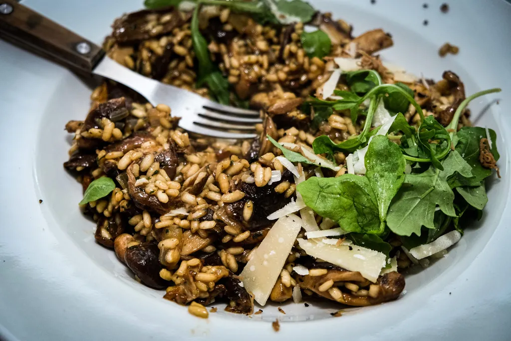 A second bowl of finished mushroom risotto from a higher angle, showing the pale colour and glossy texture.