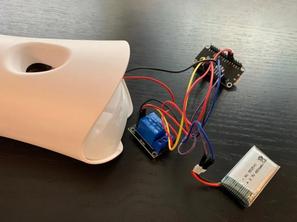 The ESP32, relay, and battery pack laid out and wired together for bench testing alongside an open Airwick body.
