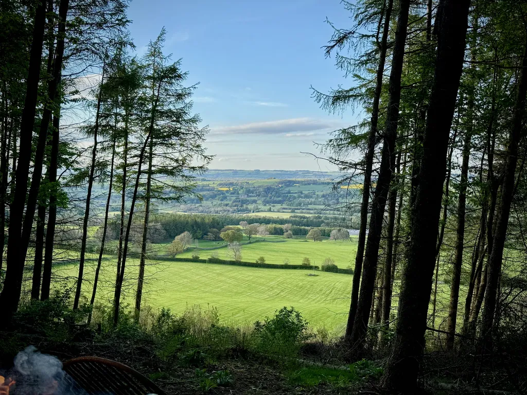 The Yorkshire valley stretching wide below the cabin deck — green fields, woodland, and open sky to the horizon.