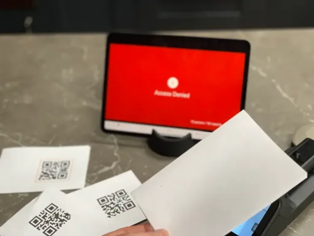 The Power App entry screen flashing red with a cross and 'not allowed' label after an invalid pass is scanned.