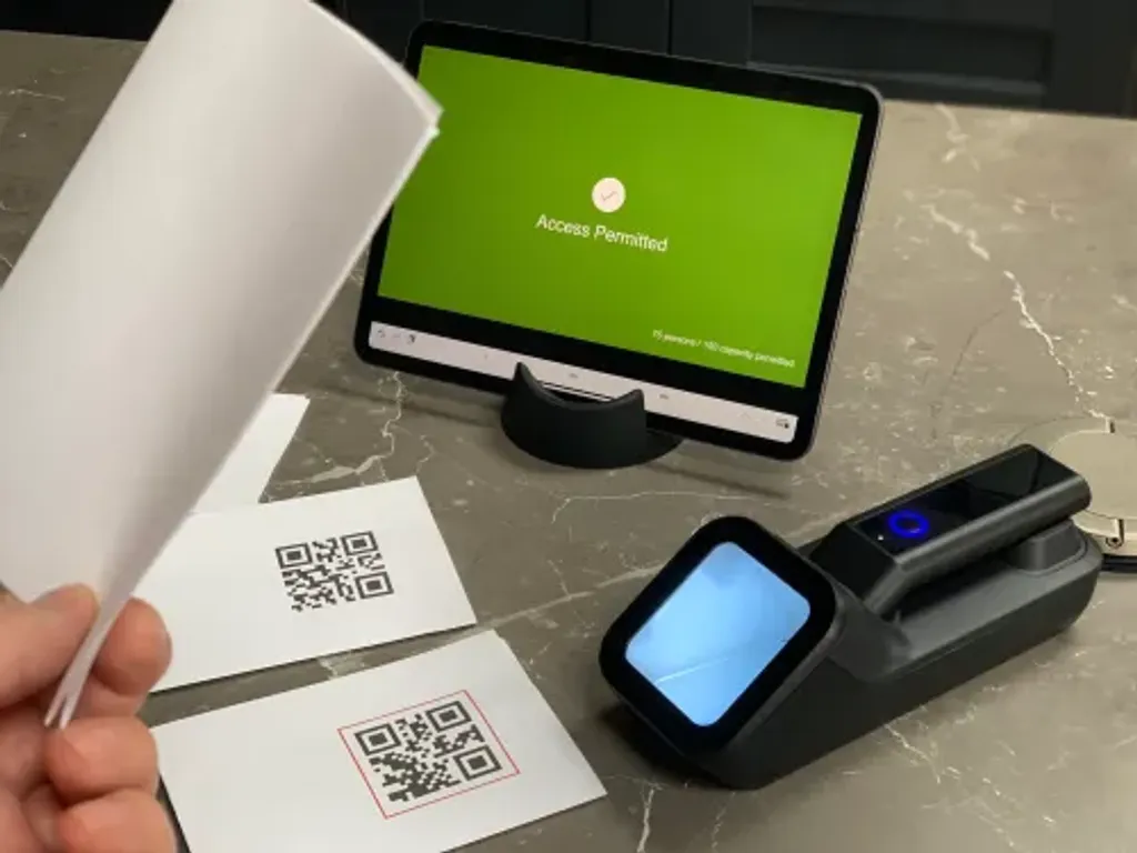 The Power App entry screen flashing green with a tick and 'permitted' label after a valid pass is scanned.