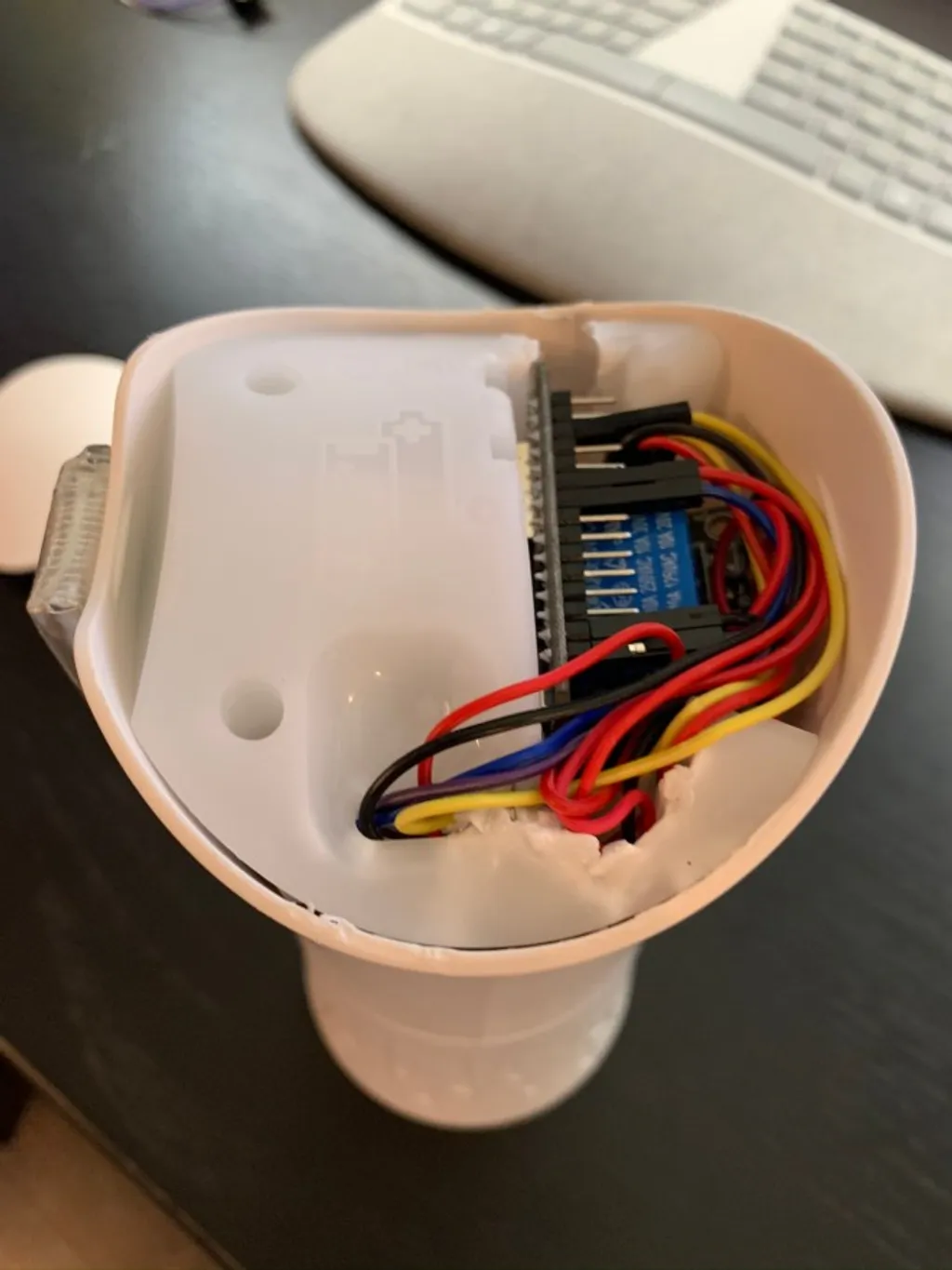 The Airwick shell open, with the ESP32, the relay, and the wiring all sat inside the original plastic insert.