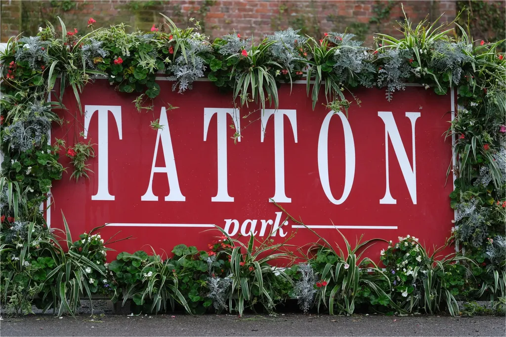 The floral-bordered red 'Tatton Park' entrance sign.