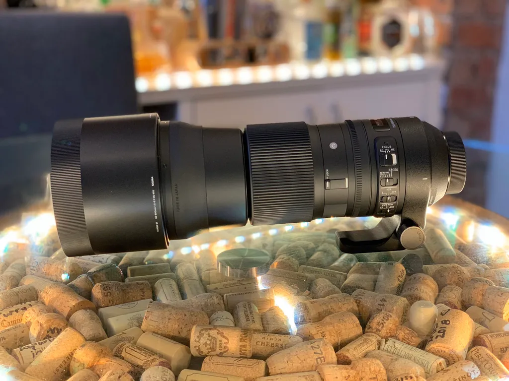 A Sigma 150-600mm telephoto lens stood on the same bowl of wine corks.