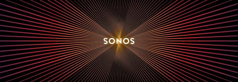 A Sonos Play:1 speaker with a USB battery pack attached to the rear with heavy-duty Velcro, sitting in front of a fireplace.