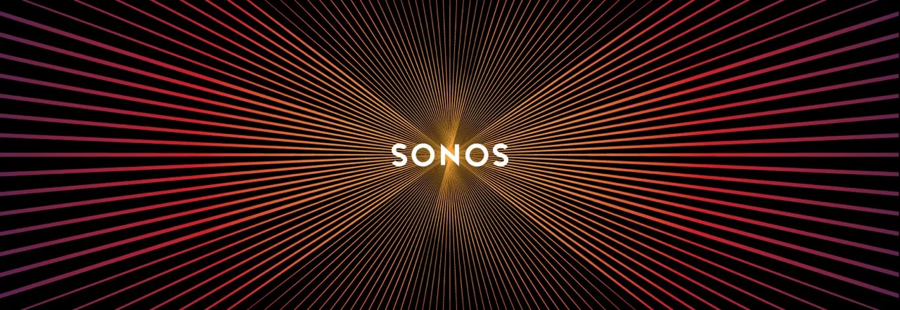 A Sonos Play:1 speaker with a USB battery pack attached to the rear with heavy-duty Velcro, sitting in front of a fireplace.