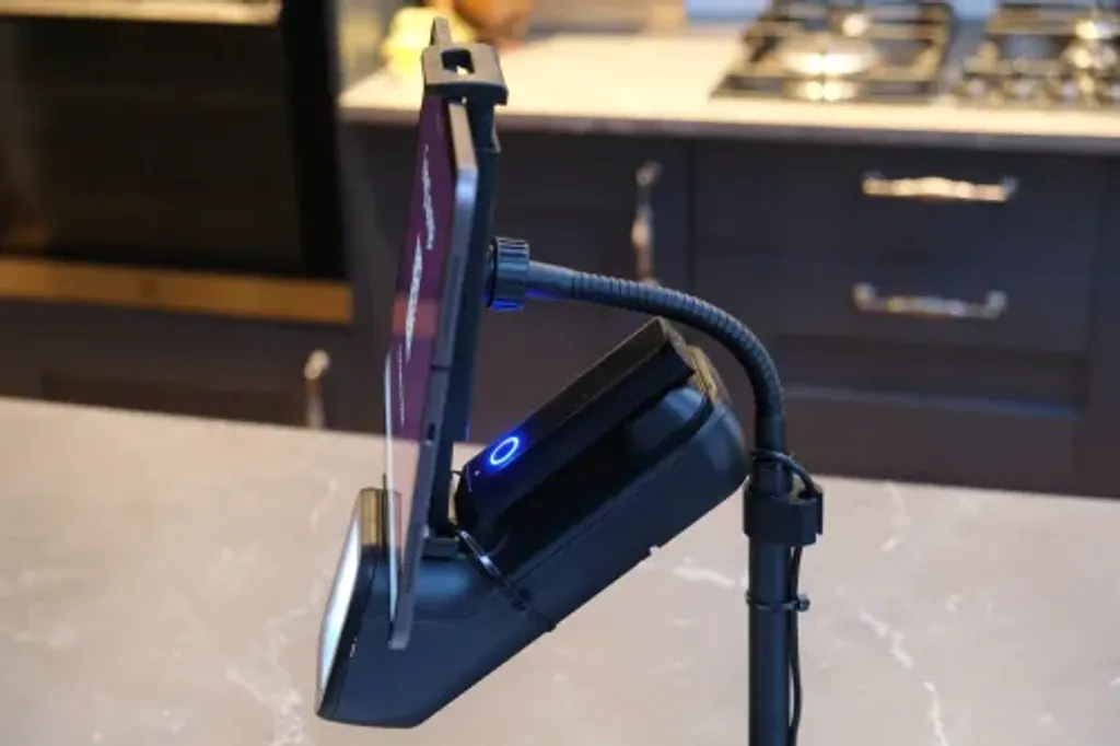 The iPad and docked Alacrity barcode scanner mounted to a stand, viewed from the side, ready for entrance staff to use.