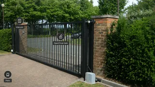A concept mockup of a UniFi Protect drive gate camera live view, with labelled shortcut bubbles: intercom, open/close gate, and panic.